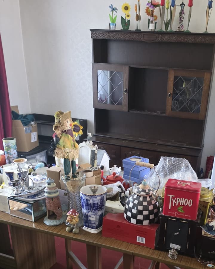 Ornaments, tins and china from a home, sorted and set out on a table